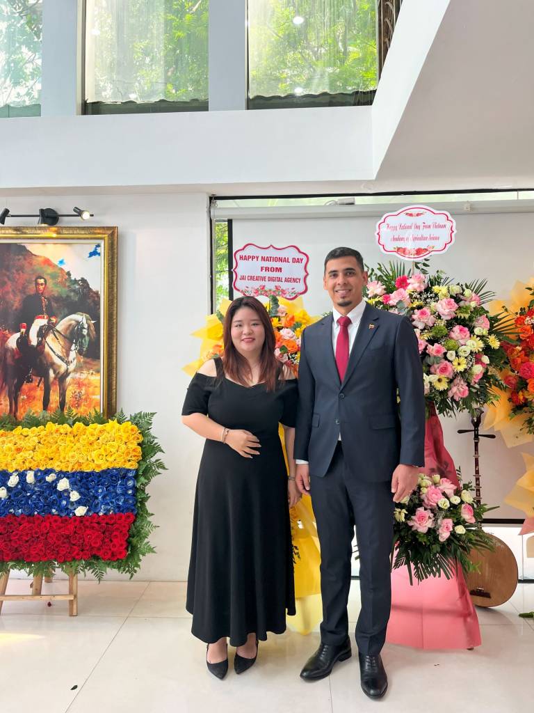 Giám Đốc thương hiệu TUT BRAND - Bà Nguyễn Minh Thu chụp ảnh lưu niệm cùng Ngài Juan Carlos Fernandes Juárez – Đại sứ Đặc mệnh Toàn quyền nước Cộng hòa Bolivar Venezuela tại khu trưng bày quốc kỳ và hình ảnh người anh hùng Simón Bolívar.